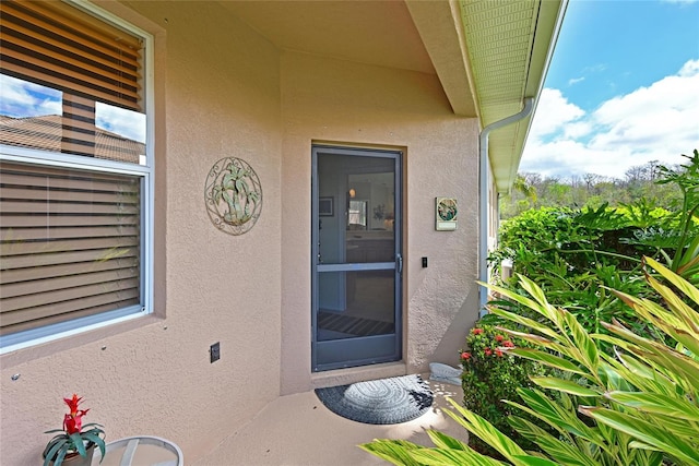 property entrance with stucco siding