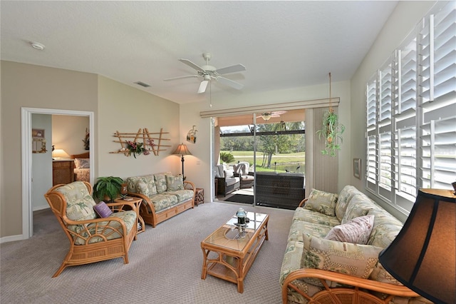 carpeted living area with visible vents, ceiling fan, and baseboards