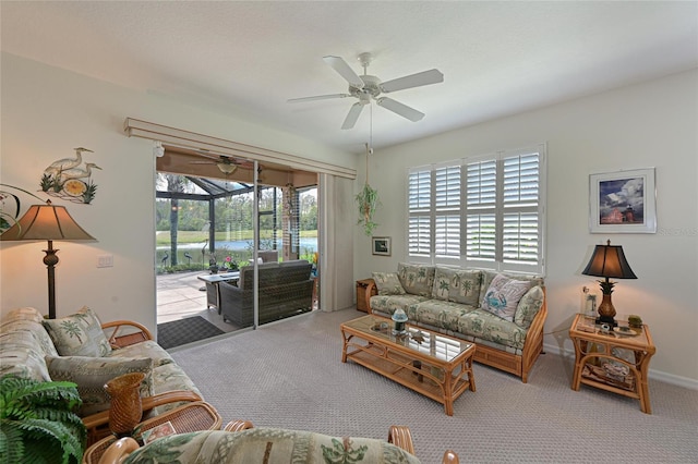 carpeted living room with a ceiling fan, a sunroom, and baseboards