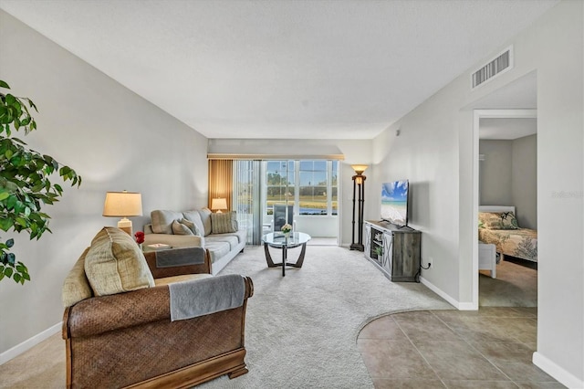 carpeted living room with visible vents and baseboards