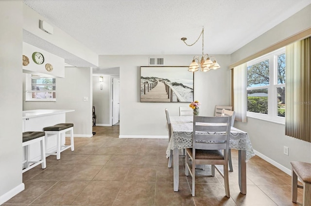 tiled dining room featuring baseboards, visible vents, a chandelier, and a wealth of natural light