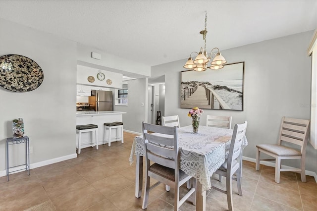 dining area with light tile patterned floors, baseboards, and an inviting chandelier