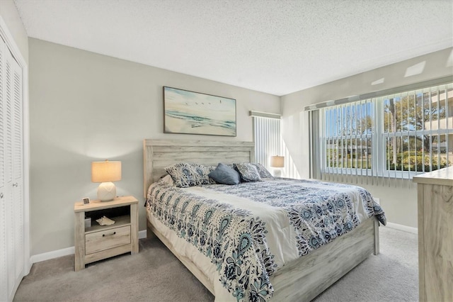 carpeted bedroom with a closet, baseboards, and a textured ceiling