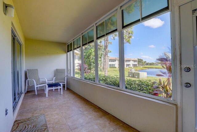 unfurnished sunroom featuring a water view