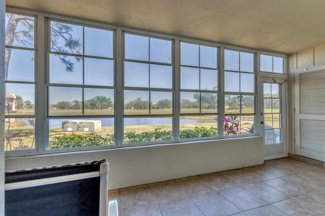 unfurnished sunroom featuring a water view