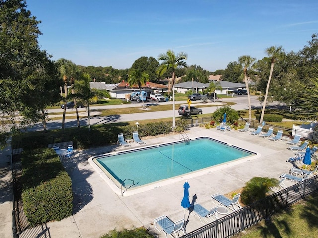 pool with a patio and fence