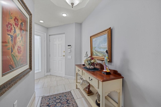 foyer with baseboards and light tile patterned flooring