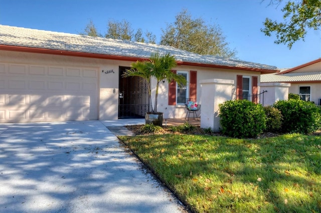 ranch-style house with concrete driveway, a tiled roof, an attached garage, and stucco siding