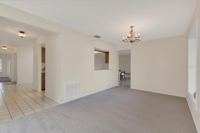 unfurnished room with a notable chandelier, light tile patterned floors, visible vents, and light colored carpet