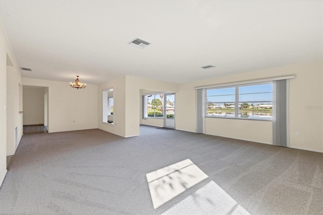 unfurnished living room featuring carpet, visible vents, and a notable chandelier