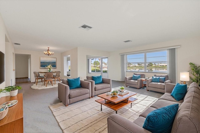 carpeted living area with visible vents and an inviting chandelier