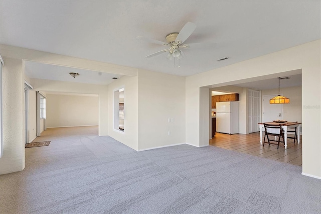 spare room featuring ceiling fan, carpet floors, visible vents, and baseboards