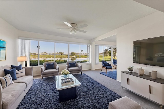 carpeted living room with ceiling fan and baseboards