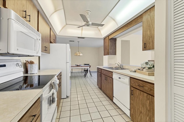 kitchen with light tile patterned floors, white appliances, a ceiling fan, light countertops, and a tray ceiling