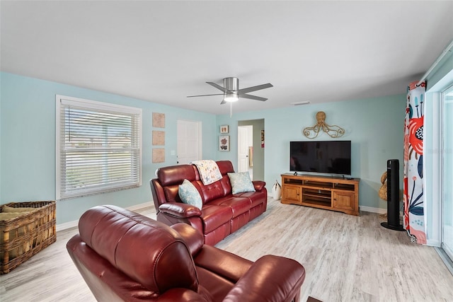 living area with a ceiling fan, baseboards, and wood finished floors