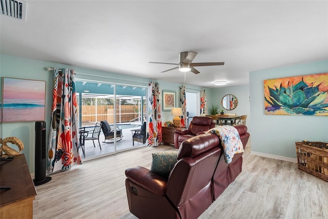 living area with a ceiling fan, visible vents, baseboards, and wood finished floors