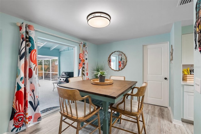 dining area featuring light wood-type flooring and visible vents