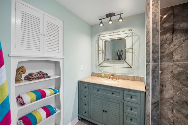 full bath with tiled shower and vanity