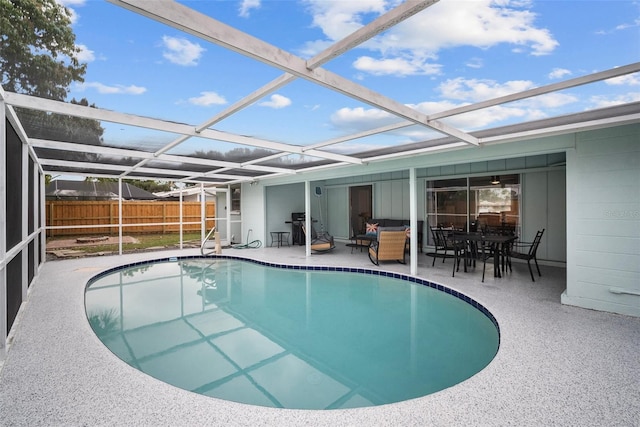 view of swimming pool featuring glass enclosure, a patio area, fence, and a fenced in pool