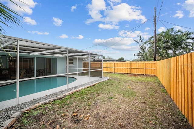 exterior space featuring glass enclosure, a fenced backyard, a patio area, and a fenced in pool