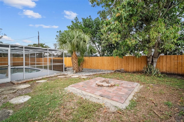 view of yard with a fenced in pool, glass enclosure, a fenced backyard, and a patio