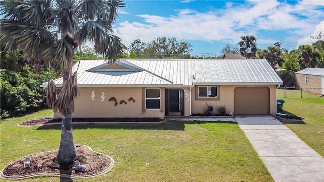 view of front of property with metal roof, an attached garage, concrete driveway, stucco siding, and a front yard