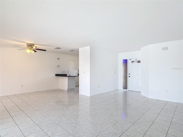 spare room with light tile patterned floors and a ceiling fan