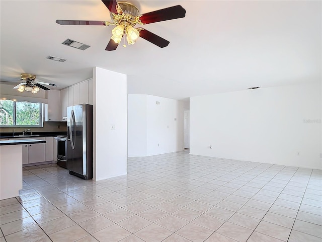 kitchen with stainless steel appliances, dark countertops, visible vents, open floor plan, and white cabinetry