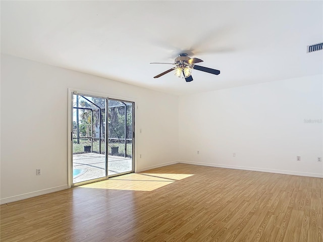 unfurnished room with a ceiling fan, light wood-style flooring, visible vents, and baseboards