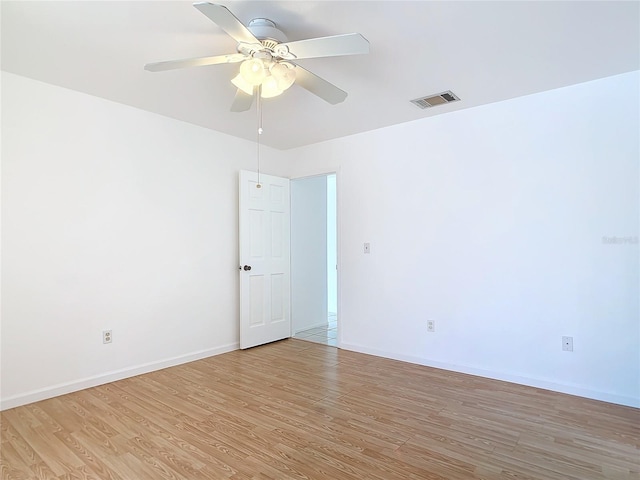 unfurnished room with light wood-style floors, baseboards, visible vents, and ceiling fan