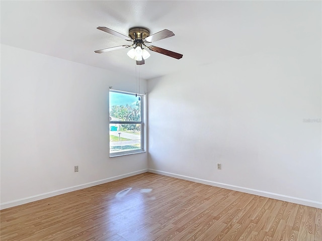 unfurnished room featuring a ceiling fan, light wood finished floors, and baseboards