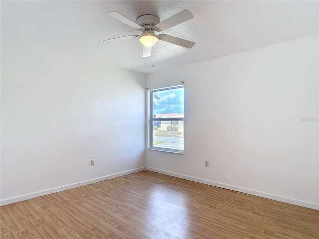 spare room with a ceiling fan, baseboards, and light wood finished floors