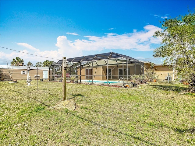 rear view of house featuring an outdoor pool, glass enclosure, a yard, and central AC unit