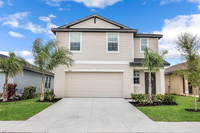 traditional-style house with driveway, a garage, a front lawn, and stucco siding