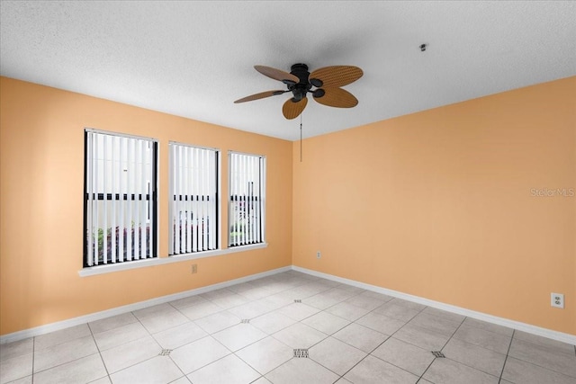 empty room with a ceiling fan, a textured ceiling, and baseboards