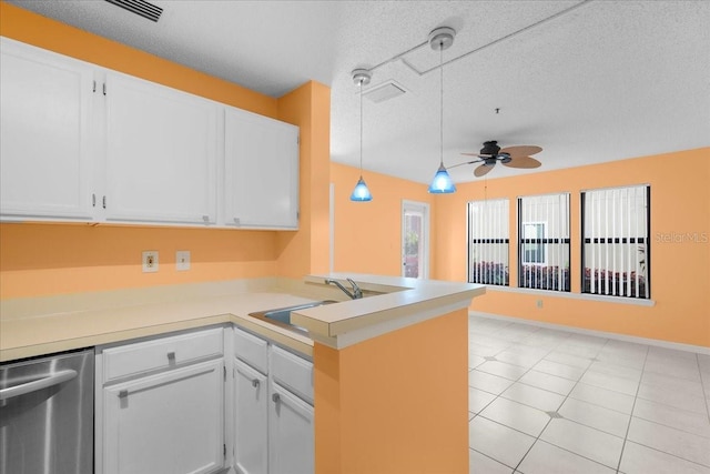 kitchen featuring light countertops, white cabinetry, a sink, dishwasher, and a peninsula