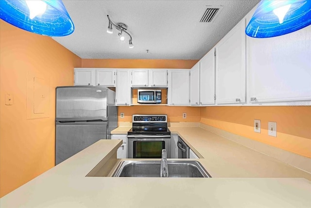 kitchen with stainless steel appliances, a sink, visible vents, white cabinetry, and light countertops