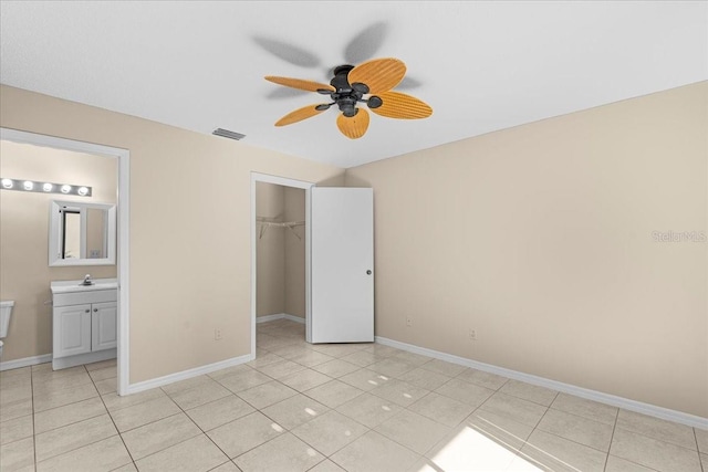 unfurnished bedroom featuring light tile patterned floors, a sink, visible vents, and baseboards