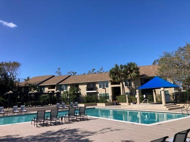 pool with a patio area and fence