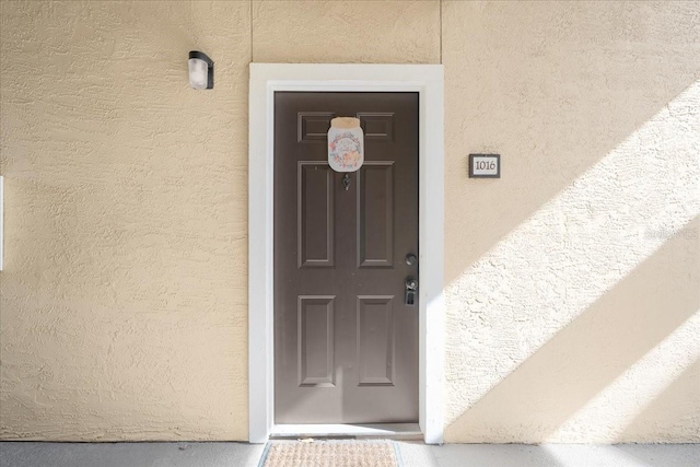 view of exterior entry featuring stucco siding