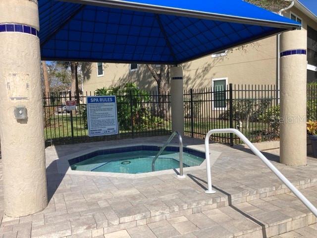 view of swimming pool with a hot tub, fence, and a gazebo