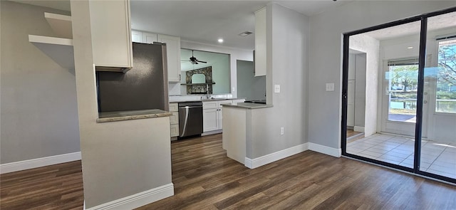 kitchen featuring dark wood finished floors, light countertops, white cabinetry, dishwasher, and baseboards