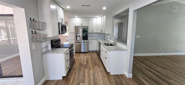 kitchen featuring visible vents, dark wood finished floors, white cabinets, appliances with stainless steel finishes, and a sink