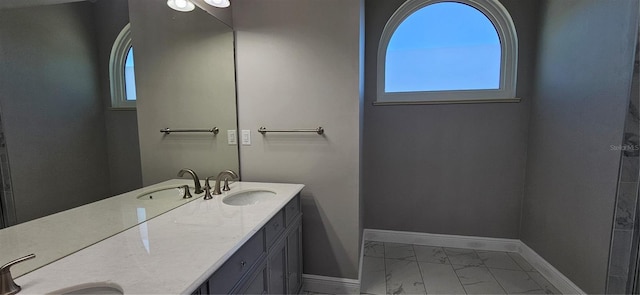 bathroom featuring marble finish floor, baseboards, and a sink