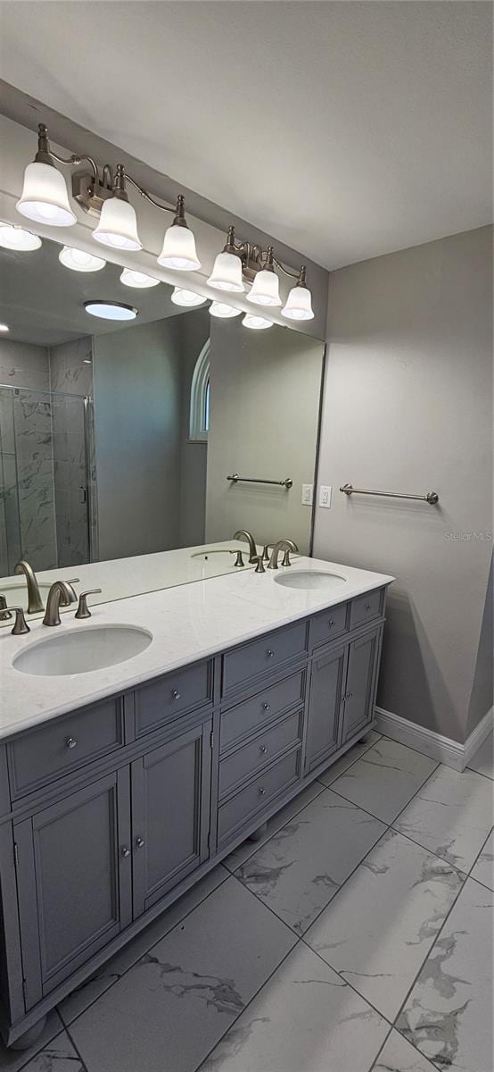 bathroom with marble finish floor, double vanity, a sink, and a shower stall