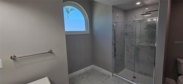 full bath with marble finish floor, a marble finish shower, toilet, and baseboards