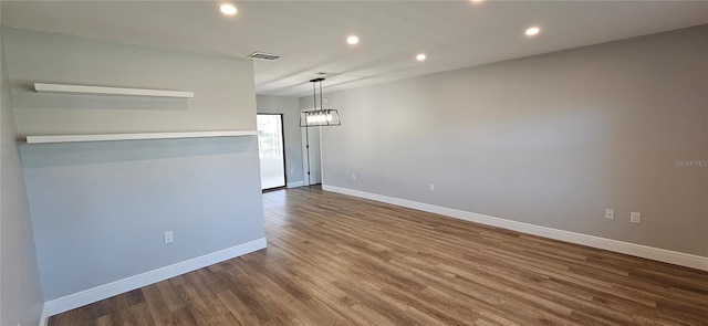 empty room featuring baseboards, visible vents, wood finished floors, and recessed lighting