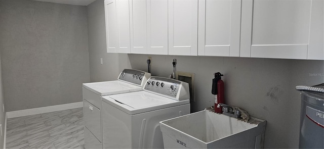 laundry area with marble finish floor, washer and clothes dryer, cabinet space, a sink, and baseboards