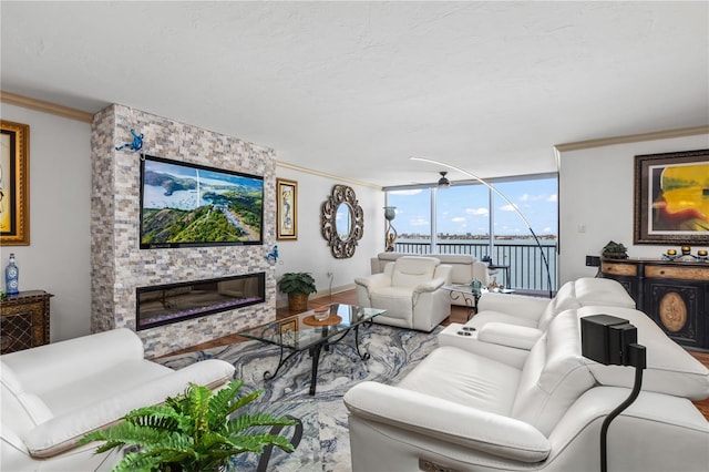 living area featuring a fireplace, wood finished floors, and crown molding