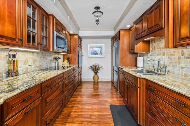 kitchen featuring dark wood-style floors, appliances with stainless steel finishes, glass insert cabinets, a sink, and light stone countertops